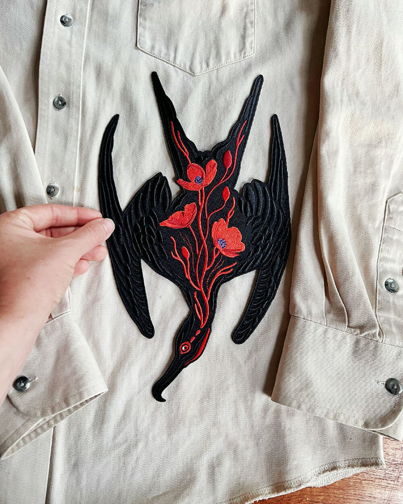 Black and red floral patch on a beige shirt