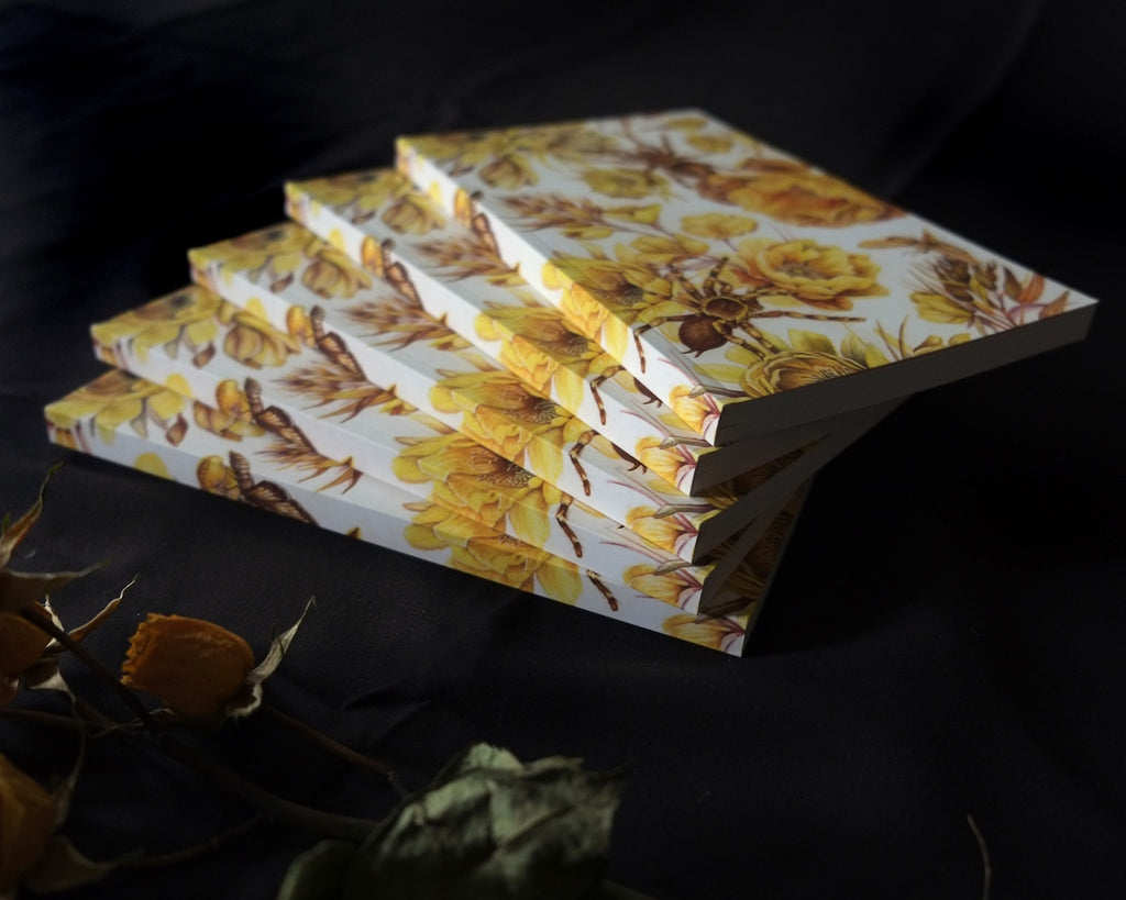 Blank notebook with repeating pattern of yellow flowers and tarantulas.