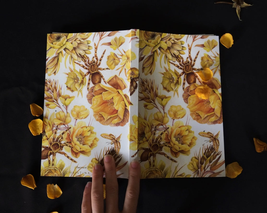 Blank notebook with repeating pattern of yellow flowers and tarantulas.