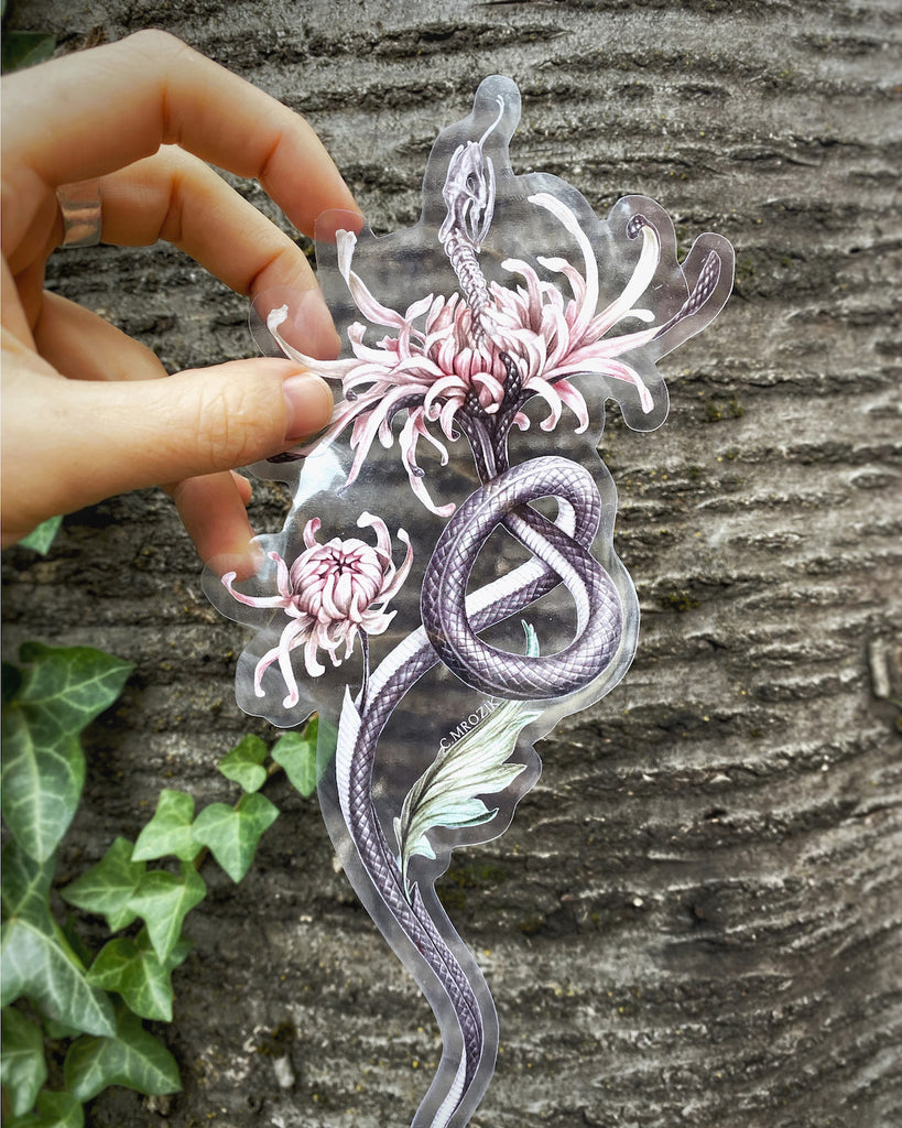 Large, clear-backed sticker with grey snake skeleton coming out of a pink chrysanthemum.