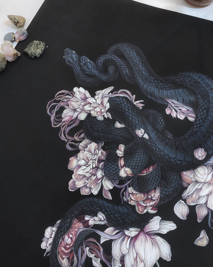 Art print of two black snakes on a bed of pink flower petals with black background.