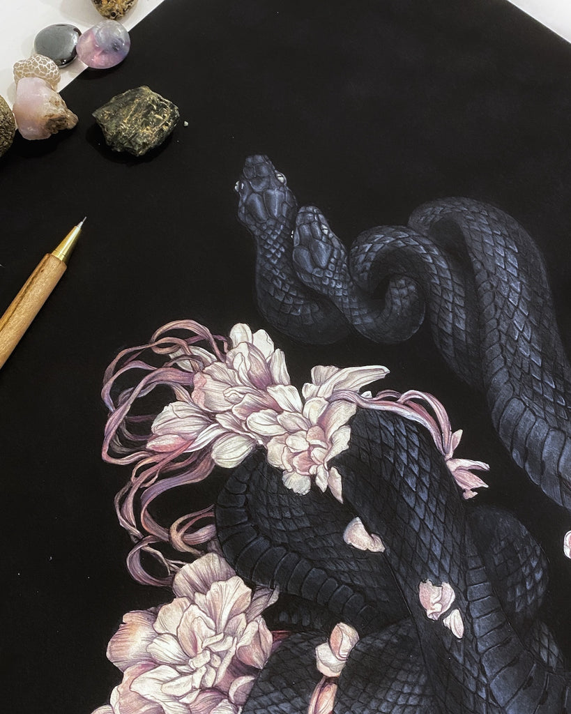 Art print of two black snakes on a bed of pink flower petals with black background.