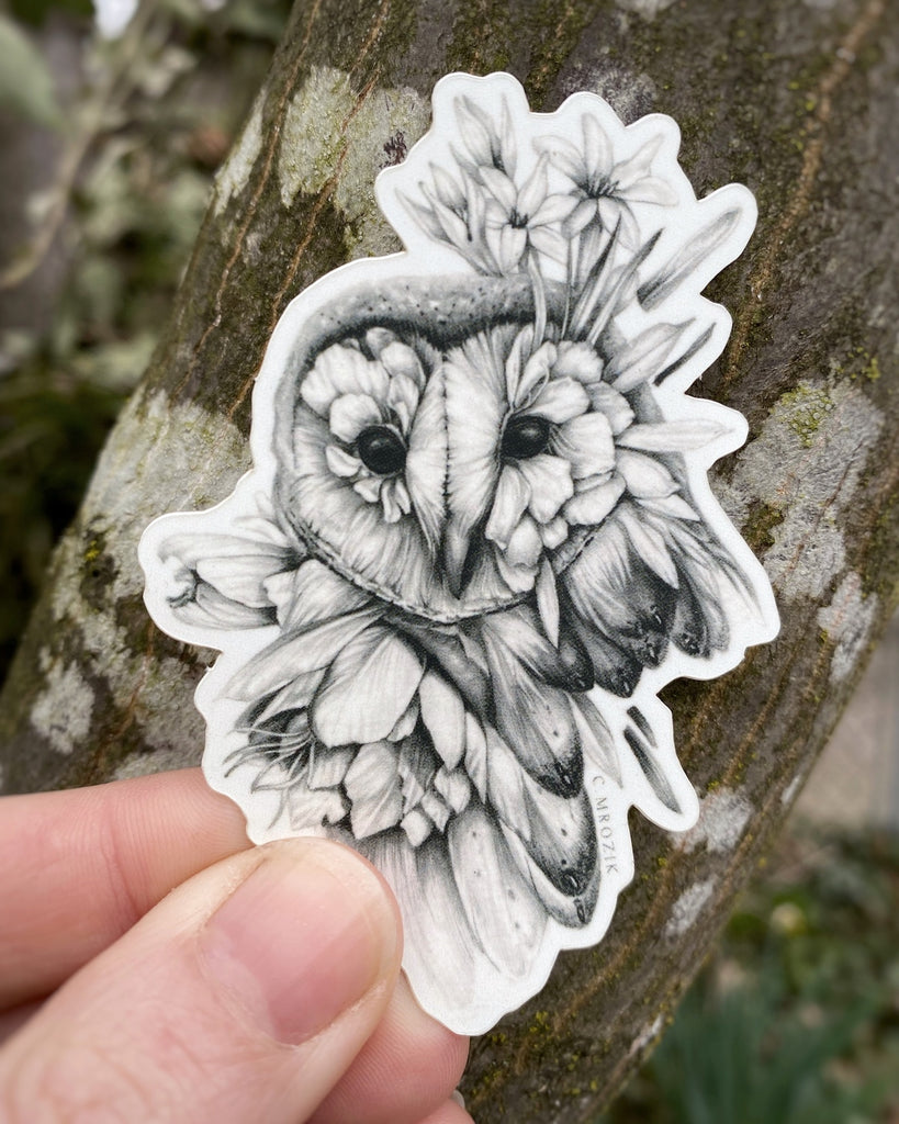 Small matte sticker with a graphite drawing of an owl head made of flower petals on a white background.