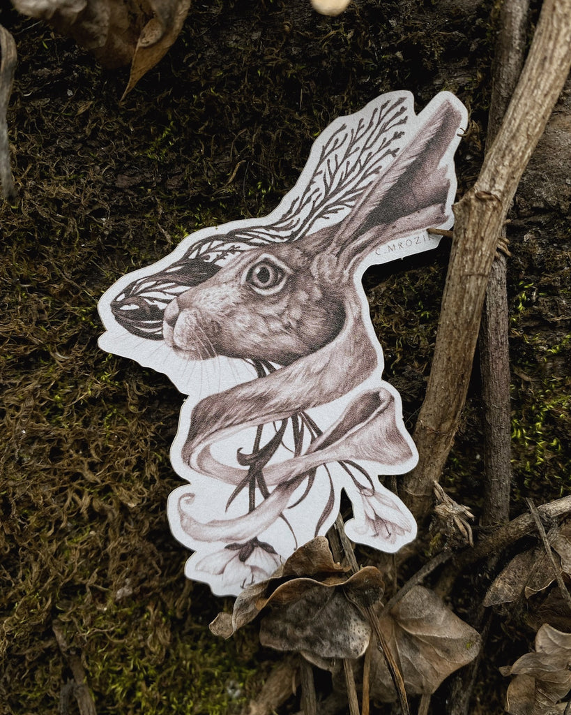 Small matte sticker with a sepia tone rabbit head intertwined with flower roots on a white background.