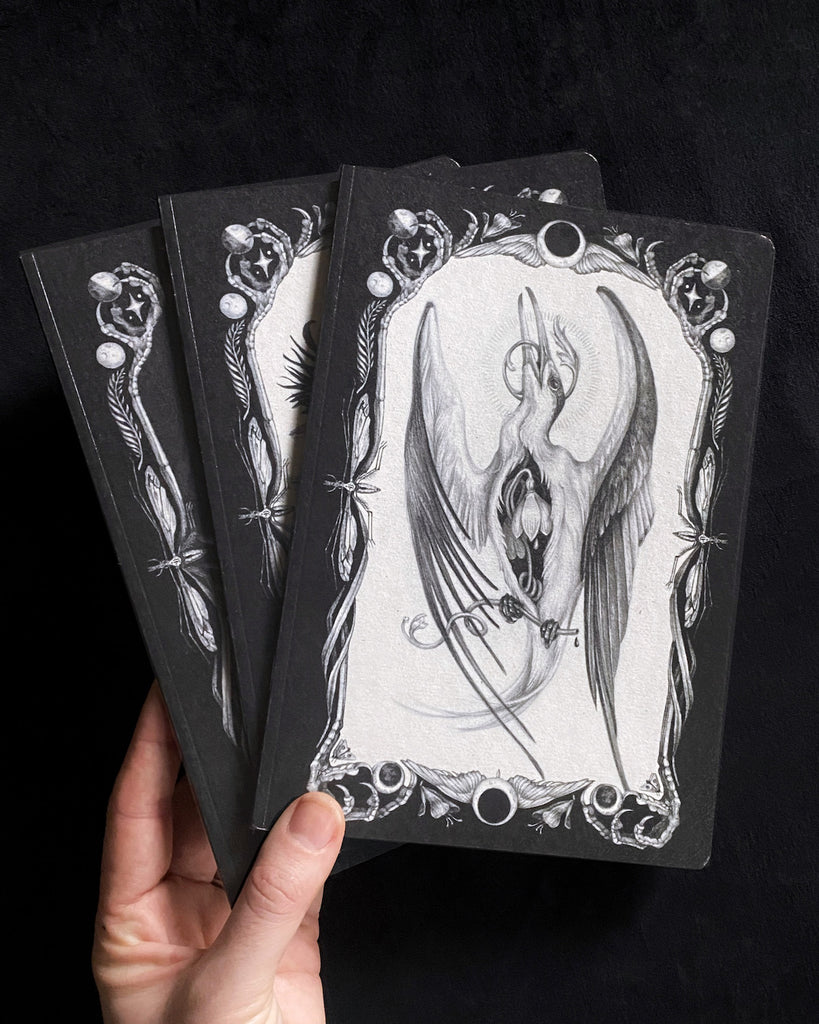 Set of three blank notebooks featuring black and white, tarot-themed illustrations of birds on the cover.