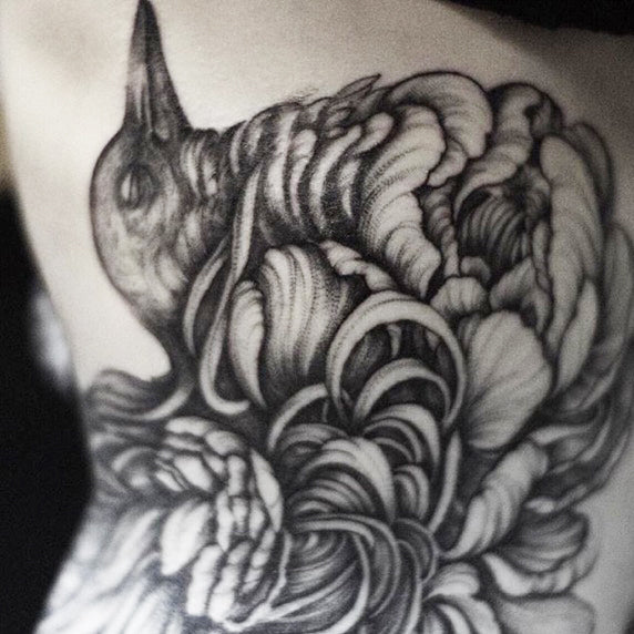 A white person’s arm with a sleeve tattoo inspired by the artwork of Christina Mrozik.