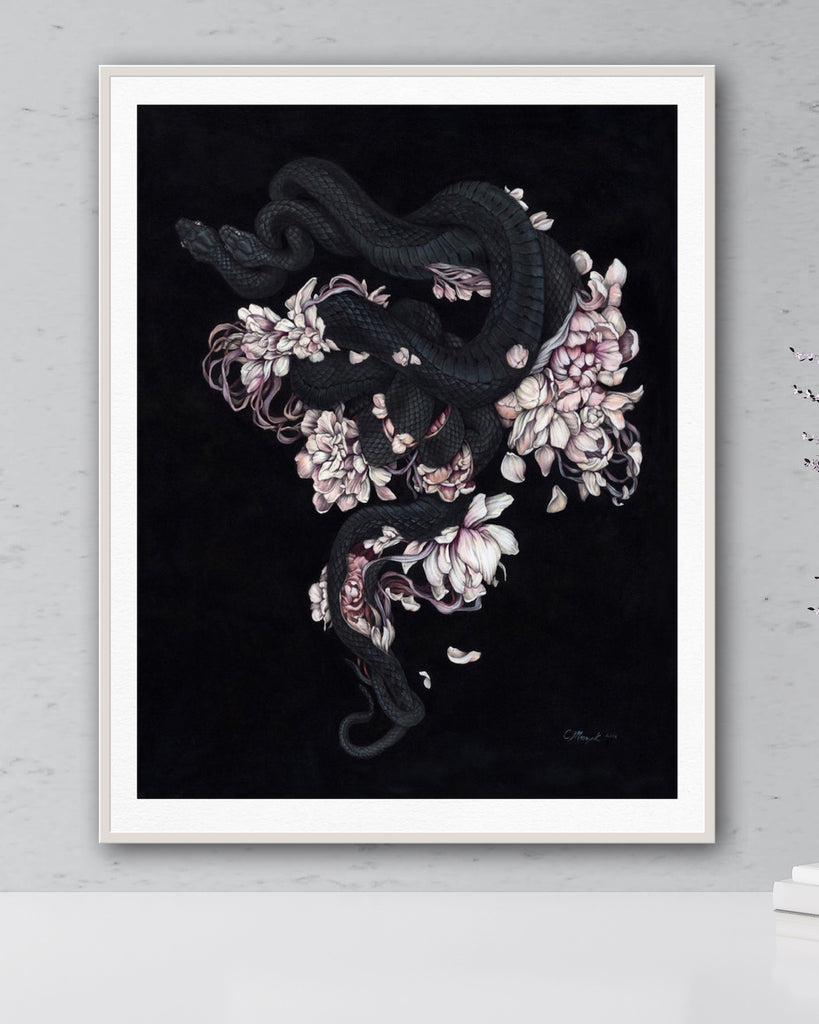 Art print of two black snakes on a bed of pink flower petals with black background.