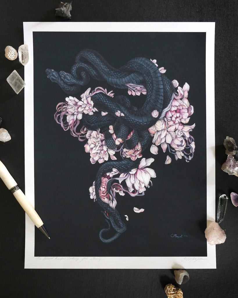 Art print of two black snakes on a bed of pink flower petals with black background.